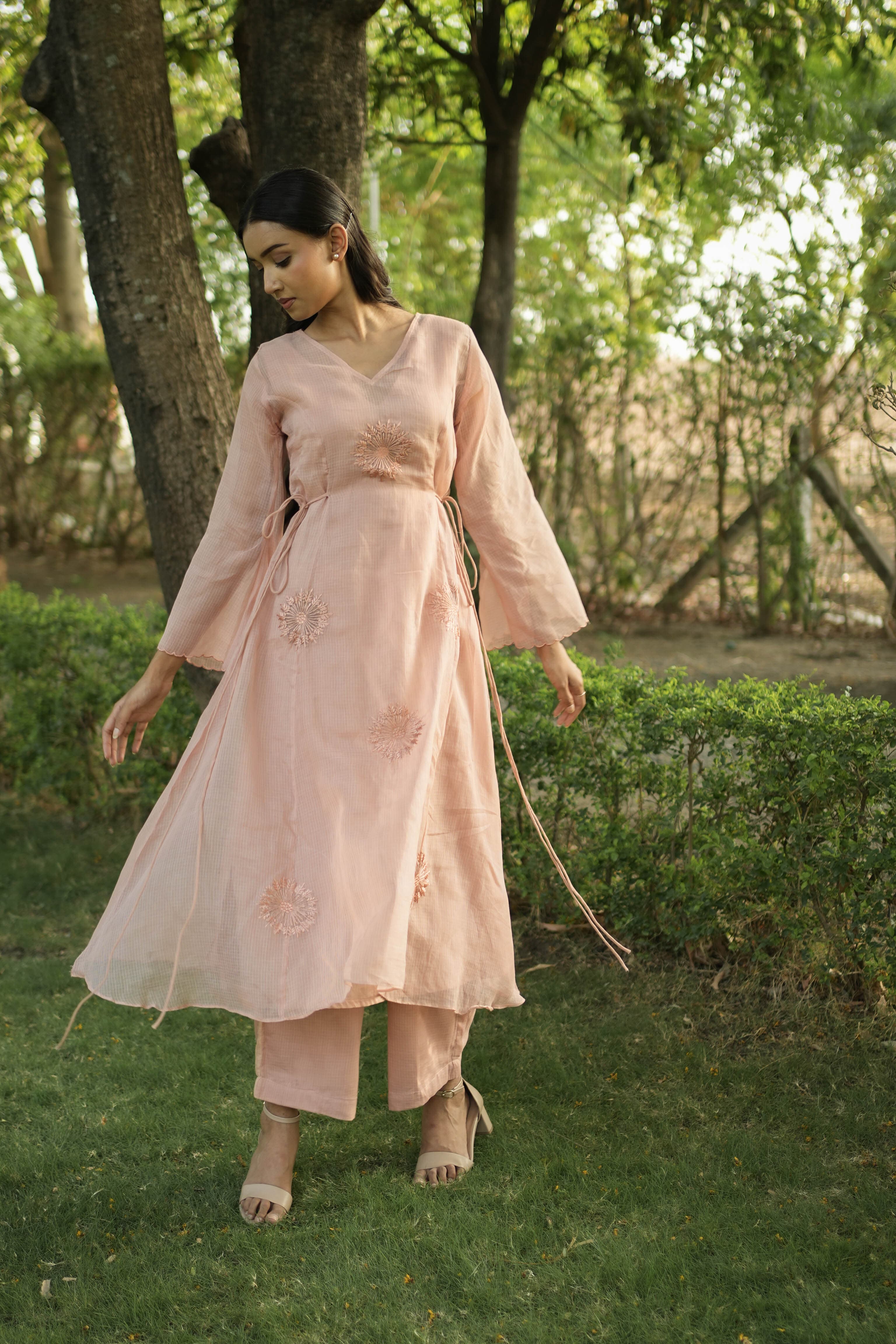 Woman wearing the Apricot Bloom peach kota kurta set in a garden