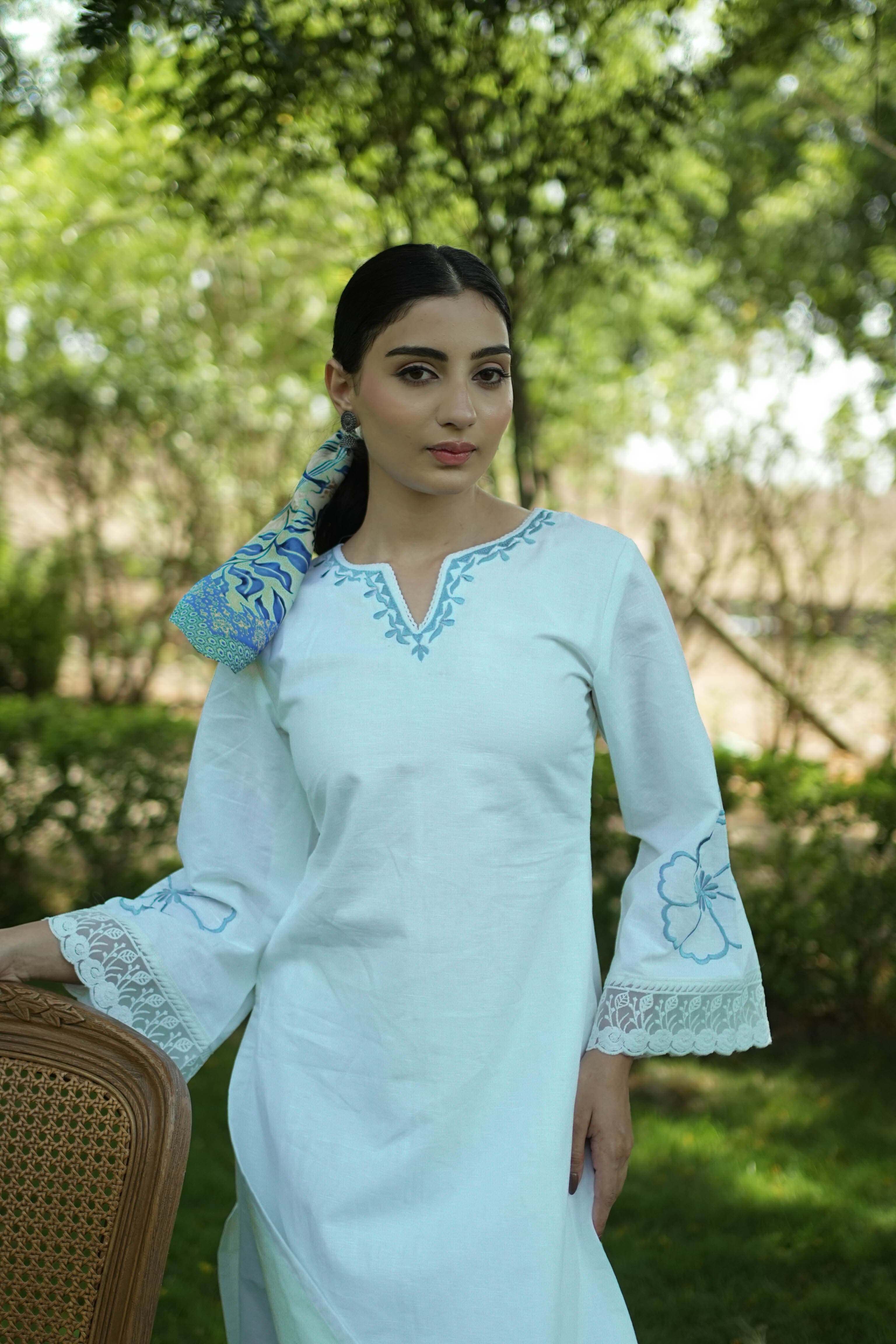 Woman wearing the Snowdrop white linen kurta set with blue embroidery